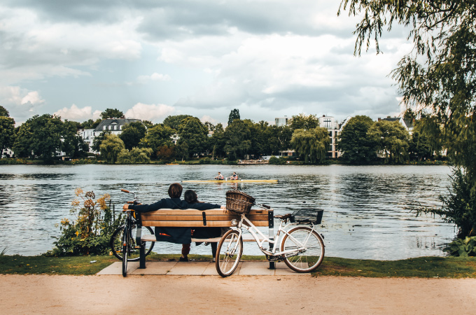 A couple is sitting on a bench enjoying the view in a park.