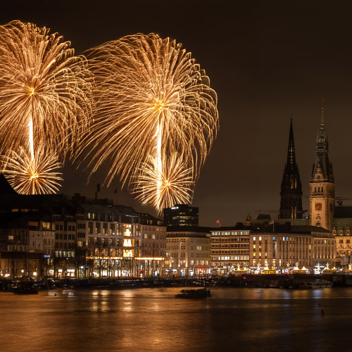 View across the Inner Alster to the buildings and the golden fireworks in the sky