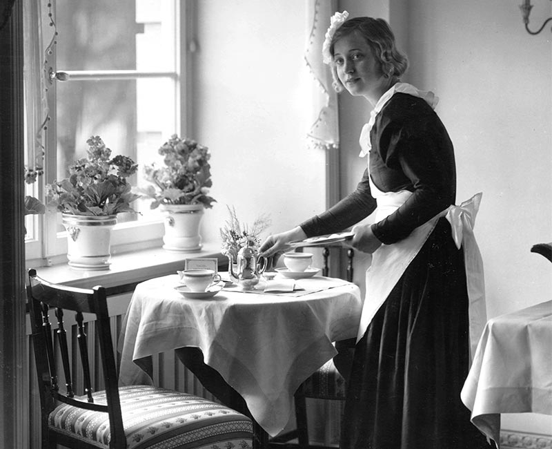 Historische schwarzweiß Aufnahme einer Condi Damen in weiß gestärkter Schürze und Häubchen im Café Condi im Hotel Vier Jahreszeiten in Hamburg