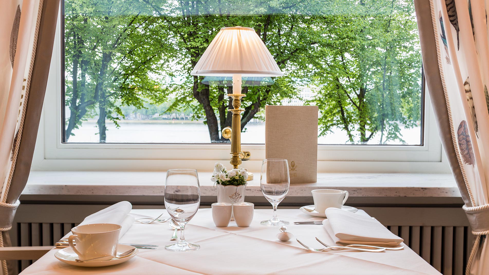 Nahaufnahme eines weiß gedeckten Tisches mit Blick aus dem Fenster im Café Condi Hamburg